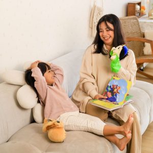 Membaca buku dengan boneka tangan